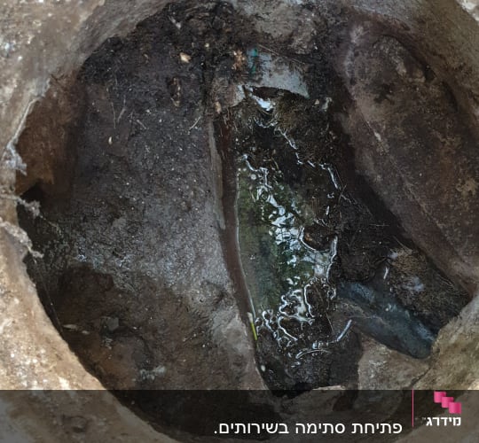 פתח ביוב עם מים עומדים ולכלוך